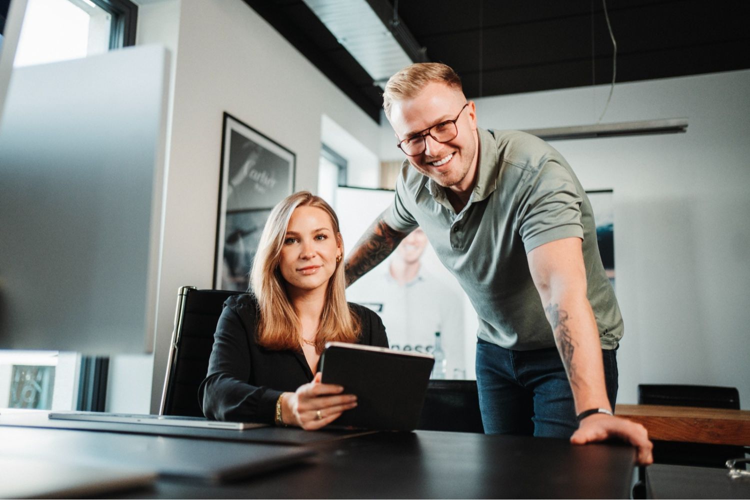Ein Agentur-Team arbeitet im Büro am Tablet, um Strategien zu entwickeln und mit Prozessoptimierung mehr Umsatz zu generieren.